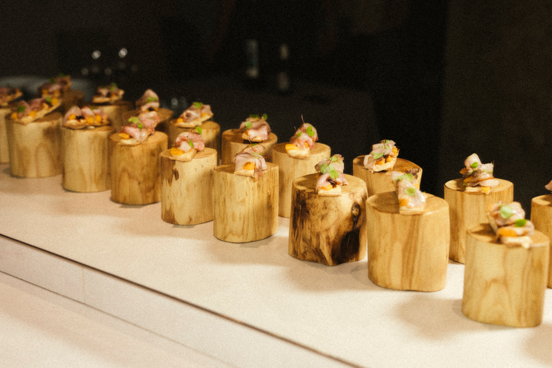 Canapés sobre soportes de madera en un evento del chef en Málaga